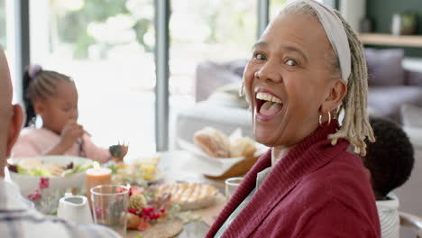 Portrait-of-african-american-grandmother-with-family-at-thanksgiving-dinner-table-,-slow-motion