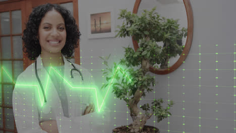 Animation-of-cardiograph-over-happy-biracial-female-doctor-with-stethoscope