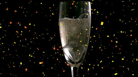 Animation-of-colorful-confetti-falling-over-champagne-glass-against-black-background