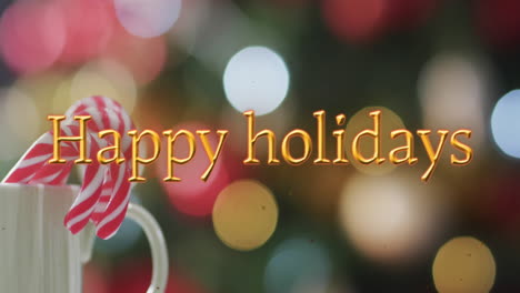 Happy-holidays-text-in-orange-with-candy-canes-over-bokeh-christmas-lights
