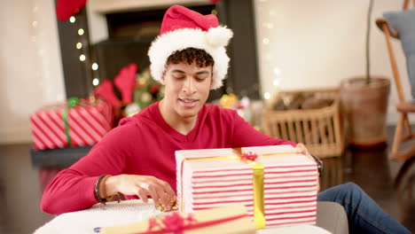 Biracial-man-wrapping-christmas-present-in-decorative-paper,-slow-motion