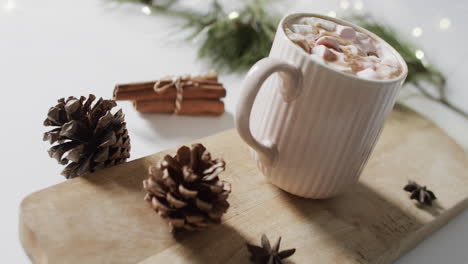 Video-of-mug-of-christmas-chocolate-on-wooden-board-and-copy-space-on-white-background
