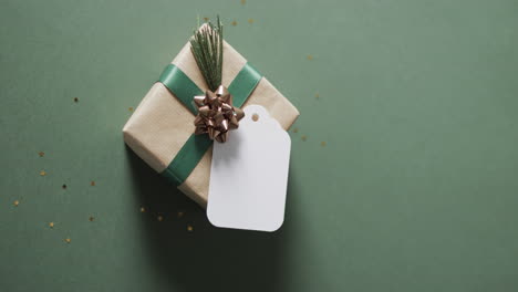 Video-of-christmas-presents-and-white-tag-with-copy-space-on-green-background