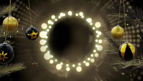 Swinging-black-and-gold-baubles-over-ring-of-yellow-christmas-lights-on-dark-background