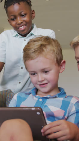Video-of-happy-diverse-boys-using-tablet-at-school