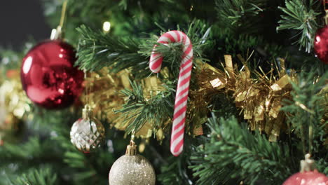 Video-of-christmas-tree-with-caandy-cane,-baubles-decorations-and-copy-space
