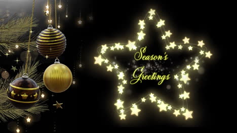 Swinging-black-and-gold-christmas-baubles-with-seasons-greetings-text-in-star-shaped-lights-on-black