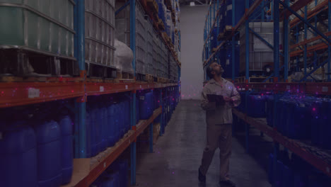 Animation-of-glowing-spots-of-light-over-caucasian-man-with-clipboard-working-in-warehouse,