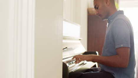 Biracial-man-playing-piano-at-home,-slow-motion