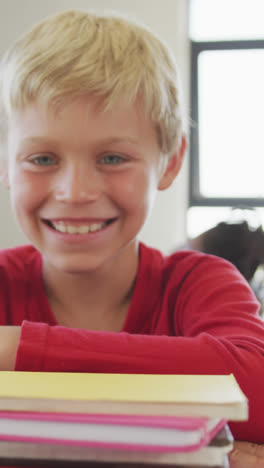 Video-of-happy-caucasian-boy-sitting-at-school-desk