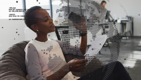 Animation-of-spinning-globe,-data-processing-on-african-american-woman-reading-a-document-at-office
