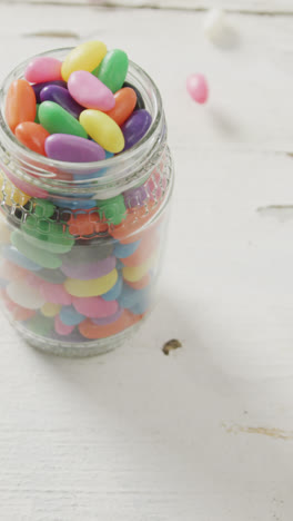 Vídeo-De-Dulces-De-Gelatina-Multicolores-En-Un-Frasco-Sobre-Fondo-Rústico-Blanco