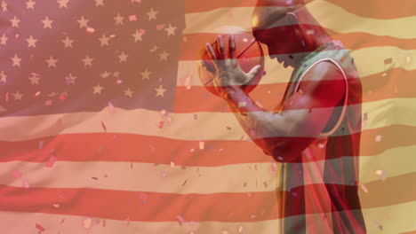 Animation-of-american-flag-over-focused-african-american-male-basketball-player-holding-ball