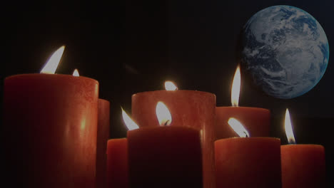 Animation-of-lit-candles-over-globe-on-black-background