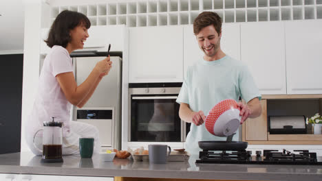 Vídeo-De-Una-Feliz-Pareja-Diversa-Preparando-El-Desayuno-Juntos-En-La-Cocina
