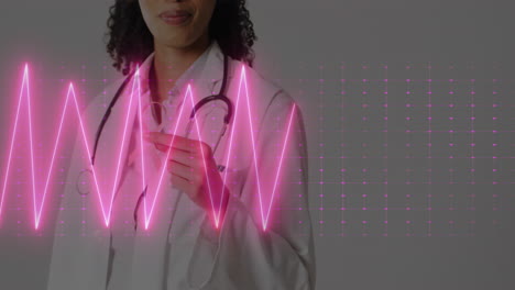 Animation-of-heart-rate-monitor-over-african-american-female-doctor-holding-ribbon-at-hospital