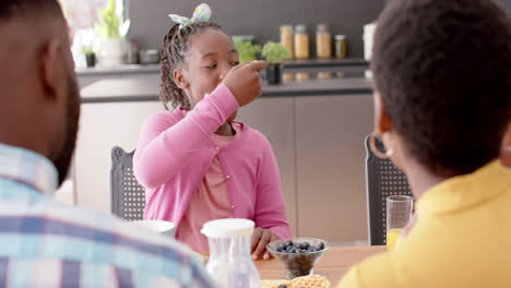 African-american-parents,-son-and-daughter-eating-in-kitchen,-slow-motion