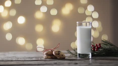 Video-of-christma-cookies,-glass-of-miljk-and-copy-space-on-wooden-background
