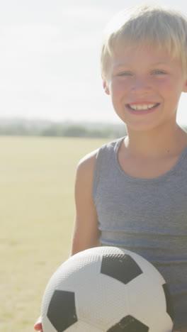 Video-Eines-Glücklichen-Kaukasischen-Jungen,-Der-Ball-Auf-Dem-Sportplatz-Hält