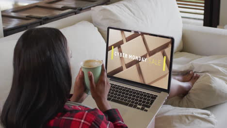 Biracial-woman-using-laptop-at-home-online-shopping-on-cyber-monday-sale-day,-slow-motion
