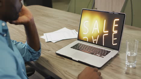 Afroamerikanischer-Mann-Mit-Laptop-Am-Tisch,-Online-Shopping-Während-Des-Verkaufs,-Zeitlupe