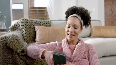 Mujer-Birracial-Feliz-Usando-Un-Teléfono-Inteligente-En-Casa,-Cámara-Lenta