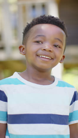 Vertical-video-of-portrait-of-happy-african-american-boy,-in-slow-motion