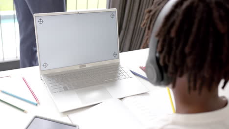 Afroamerikanischer-Junge,-Der-Einen-Laptop-Mit-Kopierplatz-Auf-Dem-Bildschirm-Für-Online-Unterricht-Zu-Hause-Verwendet,-Zeitlupe