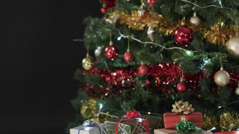 Video-of-christmas-tree-with-presents-and-fairy-lights-with-copy-space-on-black-background
