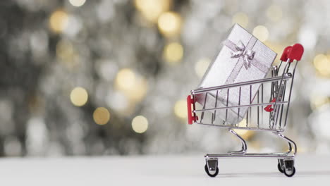 Video-of-shopping-trolley-with-christmas-decorations-and-copy-space-on-fairy-lights-background