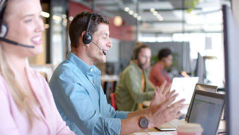 Happy-caucasian-casual-businessman-and-diverse-colleagues-using-phone-headsets,-slow-motion