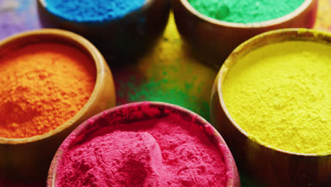 Video-of-close-up-of-multi-coloured-powders-and-bowls-with-copy-space-on-black-background