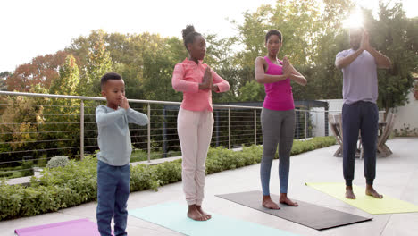 Glückliche-Afroamerikanische-Eltern,-Sohn-Und-Tochter-Praktizieren-Yoga-Im-Sonnigen-Garten,-In-Zeitlupe