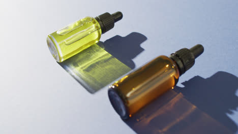 Close-up-of-dropper-serum-bottles-on-blue-background-with-copy-space