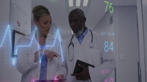 Animation-of-heart-rate-monitor-against-diverse-male-and-female-doctors-discussing-at-hospital