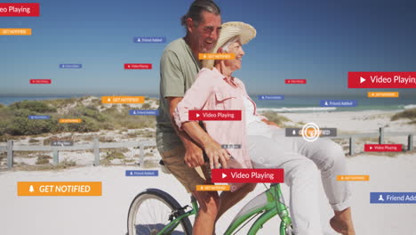 Animation-of-social-media-text-and-icons-over-caucasian-couple-riding-bike-on-beach