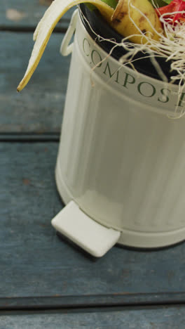 Video-of-white-compost-bin-with-organic-waste-and-copy-space-on-grey-wooden-background