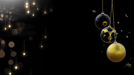 Swinging-black-and-gold-christmas-baubles-over-falling-snowflakes-on-dark-background