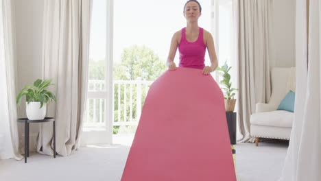 Happy-asian-woman-placing-yoga-mat-in-bedroom,-in-slow-motion