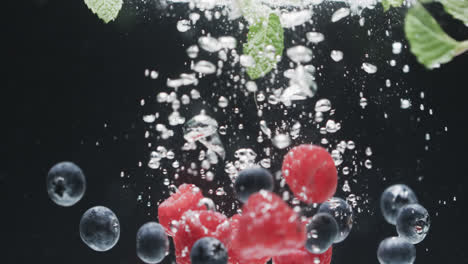 Video-of-berries-falling-into-water-with-copy-space-on-black-background