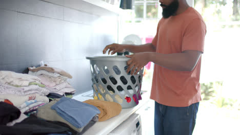 African-american-man-doing-laundry-at-home,-slow-motion