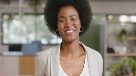 Portrait-of-happy-african-american-casual-businesswoman-with-afro-in-office,-slow-motion