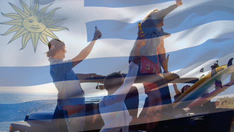 Composite-Video-Einer-Wehenden-Uruguayischen-Flagge-über-Einer-Gruppe-Unterschiedlicher-Freunde,-Die-Im-Auto-Mit-Bier-Anstoßen
