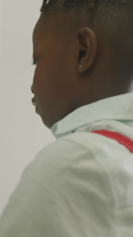 Video-of-african-american-boy-closing-locker-and-smiling-at-school