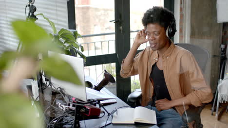 Glücklicher-Afroamerikanischer-Mann-Mit-Kopfhörern,-Der-Von-Zu-Hause-Aus-Live-Podcasts-Macht,-Platz-Zum-Kopieren,-Zeitlupe