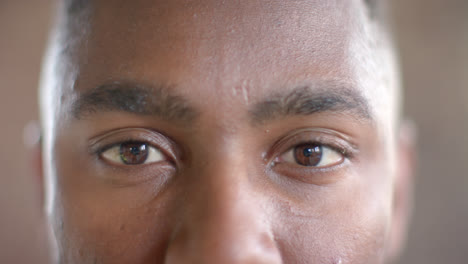 Portrait-of-happy-african-american-casual-businessman-opening-eyes-in-office-in-slow-motion