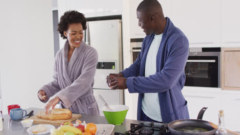 Video-of-happy-african-american-couple-preparing-breakfast-together-in-kitchen