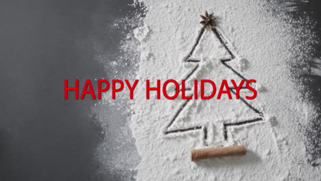 Happy-holidays-text-in-red-over-christmas-tree-drawn-in-flour-on-grey-background