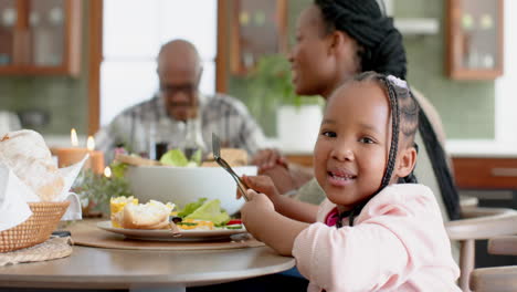 Portrait-of-african-american-daughter-with-family-at-thanksgiving-dinner-table,-slow-motion