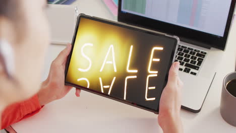 Caucasian-woman-at-desk-using-tablet,-shopping-online-during-sale,-slow-motion